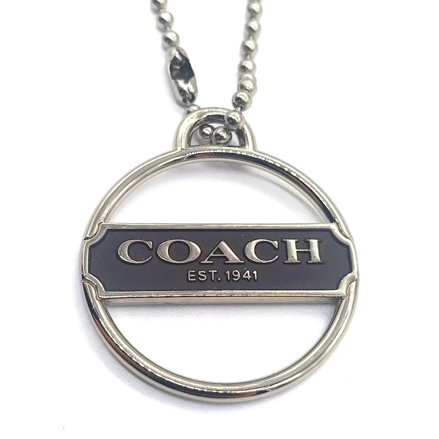 Rare COACH Keychain Fob featuring a silver medallion with black enamel and the brand logo.