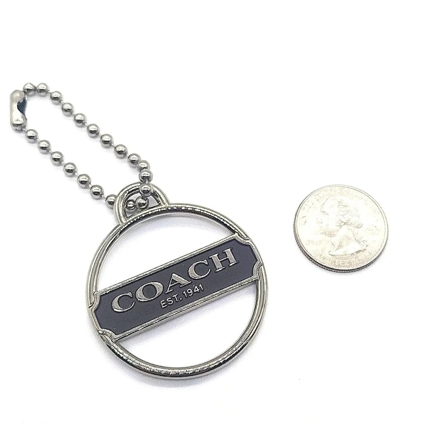 Rare COACH Keychain Fob next to a quarter for size comparison, showcasing unique espresso enamel finish.